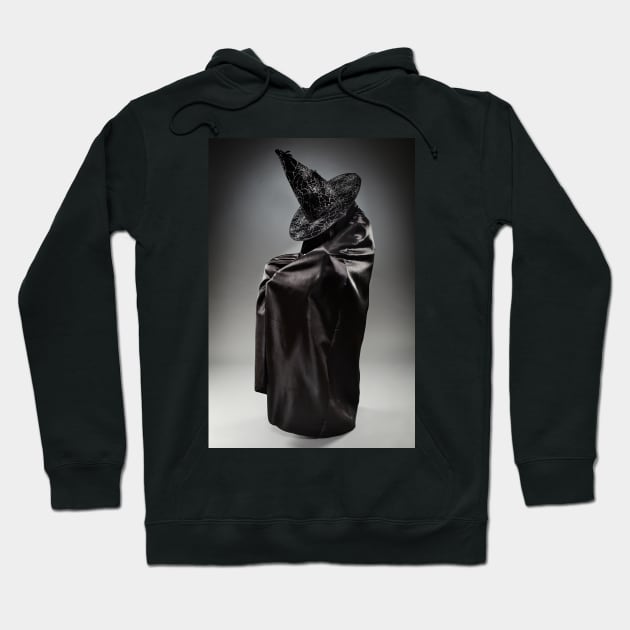 Witch wearing black attire with face hidden Hoodie by naturalis